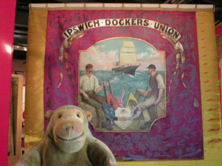 Mr Monkey looking at the front of the Ipswich Dockers Union banner
