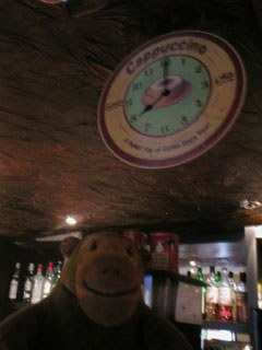 Mr Monkey looking up at a large clock inside ate o'clock