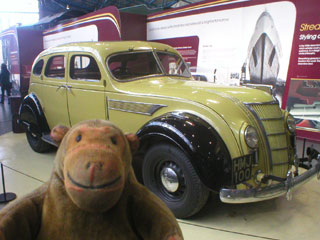 Mr Monkey looking at a Chrysler Airflow car