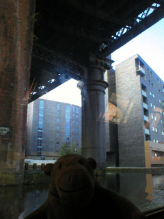 Mr Monkey looking at the Potato Wharf development from under the Great Northern Viaduct