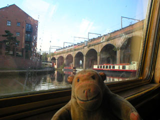 Mr Monkey looking at the Manchester, South Junction & Altrincham viaduct from the canal boat