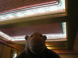 Mr Monkey looking up at the decorated ceiling of the café