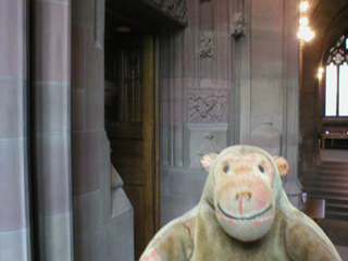Mr Monkey examining carvings on one of the doors to the Rylands Gallery