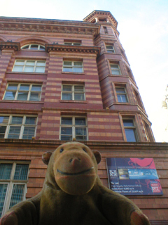 Mr Monkey looking up at Churchgate House on Oxford Street