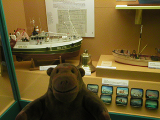 Mr Monkey looking at a cabinet about deep sea fishing