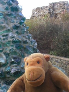 Mr Monkey beside a tower of glass