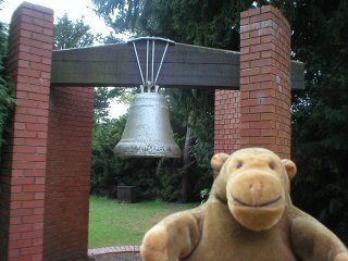 Mr Monkey in front of a bell