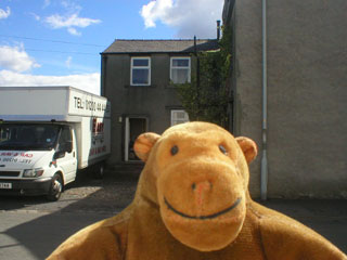 Mr Monkey in front of a cottage in Clitheroe