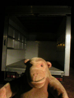 Mr Monkey outside an empty van, in the dark