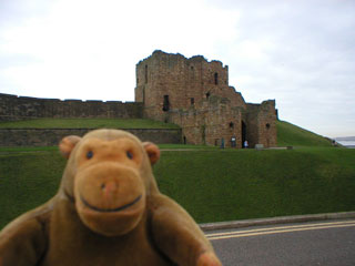 Mr Monkey in front of the gatehouse of Tynemouth castle and priory
