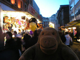 Mr Monkey in front of funfair stalls