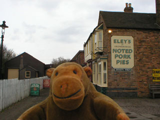 Mr Monkey with a butchers shop behind him