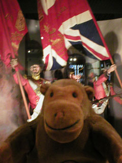 Mr Monkey in front of a display of Guards with flags