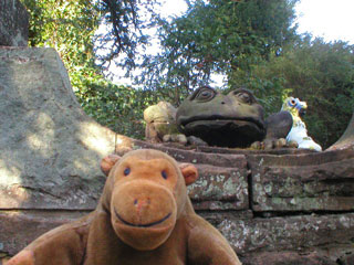 Mr Monkey beside a stone frog