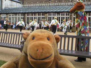 Mr Monkey watching morris men outside the Buxton Pavilion