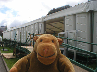 Mr Monkey next to an empty marquee