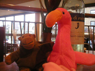 Mr Monkey on a restaurant table with Flaubert the beanie flamingo