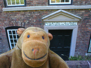 Mr Monkey beside the front door of the original mill