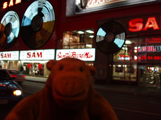 Mr Monkey across the road from a brightly lit record shop