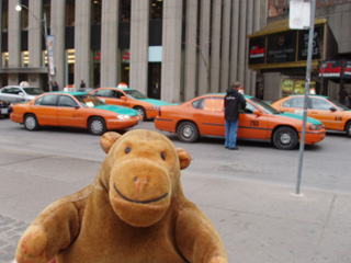 Mr Monkey in front of a streetful of annoyed taxis