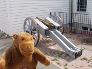 Mr Monkey with a cannon behind a building