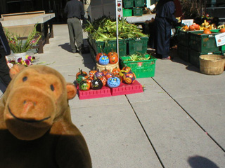 Mr Monkey looking at a stall of brightly painted pumpkins