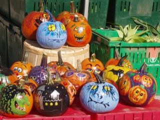 A close up of a stack of brightly painted pumpkins