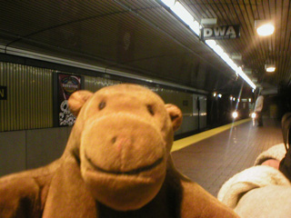 Mr Monkey on a subway platform as a train arrives