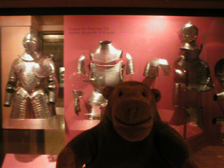 Mr Monkey in front of a case of Renaissance armour