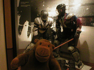 Mr Monkey in front of mannequins in ice hockey gear