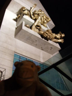 Mr Monkey looking at sculptures on the Skydome after dark
