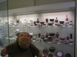 Mr Monkey in front of a cabinet of red china and white china