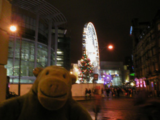 Mr Monkey looking at an illuminated ferris wheel from a distance