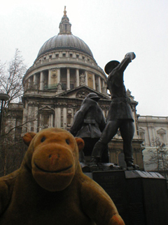 Mr Monkey looking at the firefighter's monument, with St Paul's behind it