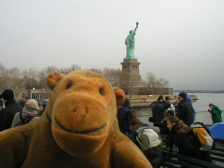 Mr Monkey on a ferry behind the Statue of Liberty