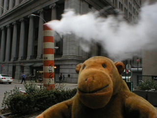 Mr Monkey in front of a manhole chimney thing
