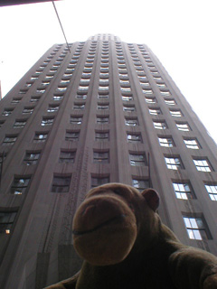 Mr Monkey looking up at One Wall Street