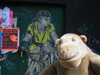Mr Monkey looking at a Swoon cutout of a cyclist