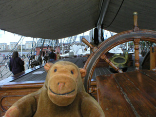 Mr Monkey looking across the poop deck from behind the ship's wheel