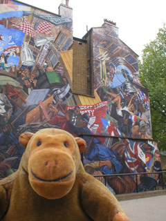 Mr Monkey in front of the right hand Cable Street mural