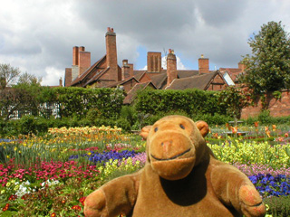Mr Monkey in the Knot Garden, with the chimneys of Nash's House beyond