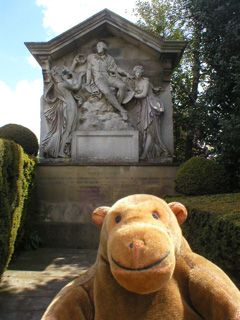 Mr Monkey in front a monument to William Shakespeare