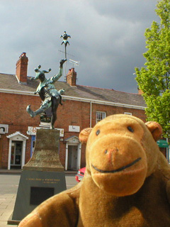 Mr Monkey looking at a statue of a jester