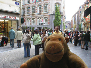 Mr Monkey walking towards a crowd of people