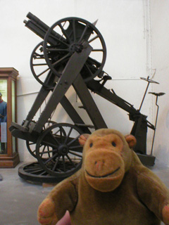 Mr Monkey in front of a field gun on an anti-aircaft mounting