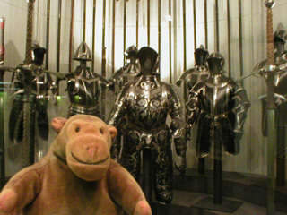 Mr Monkey in front of a display of 16th century armour