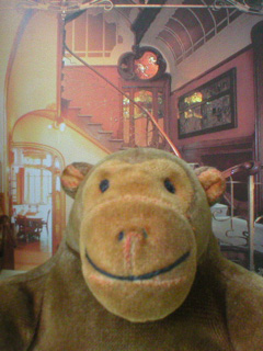 Mr Monkey in front of a picture of the landing of the bel etage