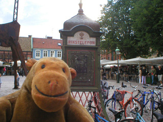 Mr Monkey next to a Rikstelefon box in Lilla Torg