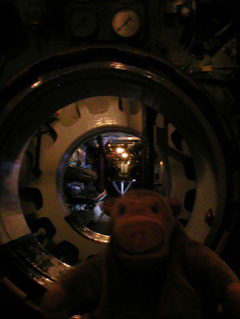 Mr Monkey looking through the submarine from the torpedo room
