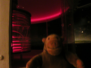 Mr Monkey beside a lighthouse lamp